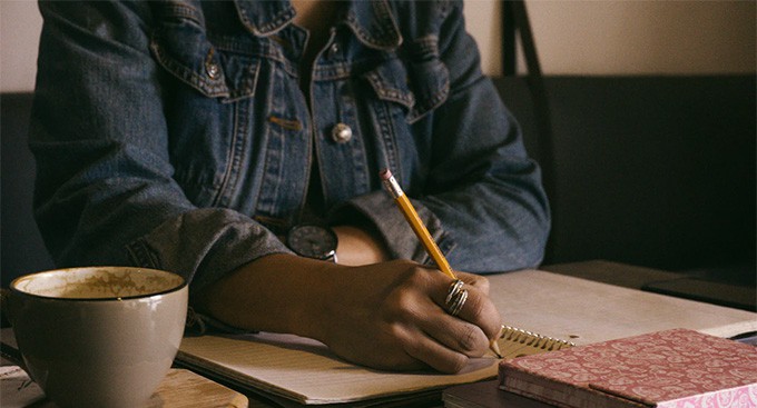 Person Writing With a Pencil