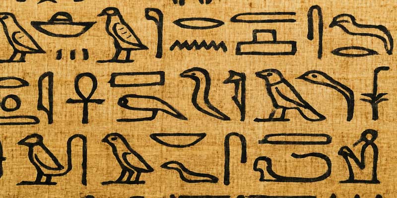 Close-up of Egyptian hieroglyphics written with black ink on aged papyrus